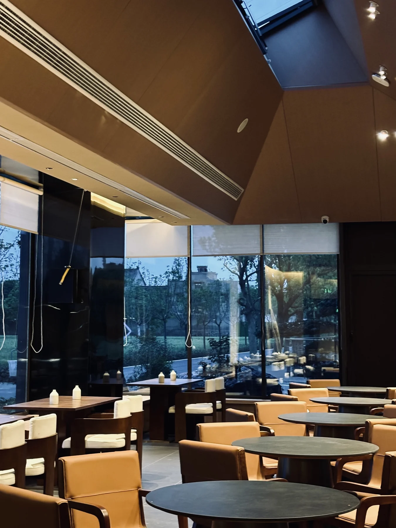 Built restaurant dining area with warm lighting, timber furniture and courtyard views